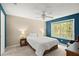 Comfortable bedroom featuring bright natural light, a ceiling fan and calming blue accent wall at 5626 River Heights Se Xing, Marietta, GA 30067