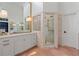 Bright bathroom with a glass-enclosed shower, double sinks, marble countertops, and stylish lighting fixtures at 6515 Ashbourne Ct, Suwanee, GA 30024