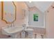 Cozy bathroom with a pedestal sink, classic fixtures, and natural light from the window at 6515 Ashbourne Ct, Suwanee, GA 30024