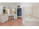 Spacious bathroom featuring a built-in vanity with ample storage and a luxurious soaking tub at 6515 Ashbourne Ct, Suwanee, GA 30024