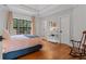 Bright bedroom featuring hardwood floors, neutral walls, and a large window at 6515 Ashbourne Ct, Suwanee, GA 30024