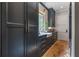 Butler's pantry with dark cabinets, stainless steel appliances, diamond windows, and brick floor tiles at 6515 Ashbourne Ct, Suwanee, GA 30024