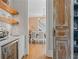 A butler's pantry featuring hardwood floors, marble counters, decorative shelving, and an antique wood door at 6515 Ashbourne Ct, Suwanee, GA 30024