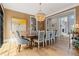 Bright dining room boasting hardwood floors, a chandelier, art, and a view into the adjacent living area at 6515 Ashbourne Ct, Suwanee, GA 30024