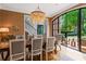 Open dining room featuring dark wood table, modern chandelier, and walk-out access to backyard patio at 6515 Ashbourne Ct, Suwanee, GA 30024
