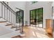 Grand entryway with hardwood floors, a staircase, and large windows offering views of the landscaped exterior at 6515 Ashbourne Ct, Suwanee, GA 30024