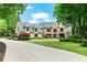 Elegant brick home with a sprawling lawn, manicured landscaping, and a long driveway at 6515 Ashbourne Ct, Suwanee, GA 30024
