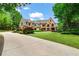 Elegant brick home with a sprawling lawn, manicured landscaping, and a long driveway at 6515 Ashbourne Ct, Suwanee, GA 30024