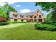 Elegant brick home with a sprawling lawn, manicured landscaping, and a long driveway at 6515 Ashbourne Ct, Suwanee, GA 30024