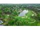 Aerial view of golf course and pond in a residential neighborhood with lush greenery and mature trees at 6515 Ashbourne Ct, Suwanee, GA 30024