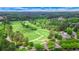 An aerial view of a lush green golf course with mature trees and elegant homes nearby at 6515 Ashbourne Ct, Suwanee, GA 30024