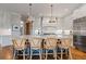Elegant kitchen featuring a large island with seating, stainless steel appliances, and stylish pendant lighting at 6515 Ashbourne Ct, Suwanee, GA 30024