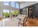 Bright living room featuring large windows, a built-in bookcase with ladder, and hardwood floors at 6515 Ashbourne Ct, Suwanee, GA 30024
