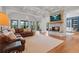Spacious living room with a stone fireplace, hardwood floors, and large windows showcasing outdoor views at 6515 Ashbourne Ct, Suwanee, GA 30024
