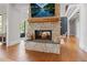 Modern living room with stone fireplace, hardwood floors, and staircase access at 6515 Ashbourne Ct, Suwanee, GA 30024
