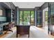 Stylish office space with built-in shelving, a classic desk, and a view of the backyard at 6515 Ashbourne Ct, Suwanee, GA 30024