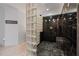 Modern shower featuring glass block wall, black marble tiles, and elegant fixtures at 6515 Ashbourne Ct, Suwanee, GA 30024