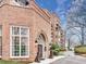 Elegant brick building exterior with arched entrance, decorative lion statues, and beautiful landscaping at 175 15Th Ne St # 304, Atlanta, GA 30309