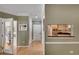 Bright hallway with hardwood floors, white doors, and a view to an office and the kitchen at 175 15Th Ne St # 304, Atlanta, GA 30309