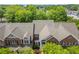 Aerial view of beautiful townhomes with manicured lawns, surrounded by mature trees and green spaces at 8730 Parker Pl, Roswell, GA 30076