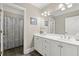 Well-lit bathroom with double sinks, white cabinets, and a large mirror with decorative lighting at 8730 Parker Pl, Roswell, GA 30076
