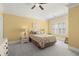 Bright bedroom with yellow walls, carpet flooring, and a bed with decorative pillows near a window at 8730 Parker Pl, Roswell, GA 30076