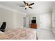 Comfortable bedroom with carpet flooring, a ceiling fan, and a wood dresser beneath a mounted television at 8730 Parker Pl, Roswell, GA 30076