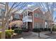 Brick townhouse featuring a covered porch, trimmed bushes and a well-manicured front lawn at 8730 Parker Pl, Roswell, GA 30076