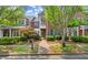 Charming two-story brick townhome with well-manicured landscaping, trees and a brick walkway leading to the entrance at 8730 Parker Pl, Roswell, GA 30076