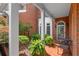 Inviting brick-paved front porch with seating, potted ferns, and brick exterior at 8730 Parker Pl, Roswell, GA 30076