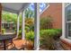 Inviting brick-paved front porch with white pillars and seating and view of the yard and front of the home at 8730 Parker Pl, Roswell, GA 30076