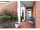 Charming covered front porch with brick flooring, creating a cozy outdoor seating area at 8730 Parker Pl, Roswell, GA 30076