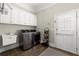 Functional laundry room with modern washer and dryer, utility sink and white cabinets at 8730 Parker Pl, Roswell, GA 30076
