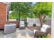 Brick home with a private patio space featuring two chairs and an A/C unit at 8730 Parker Pl, Roswell, GA 30076