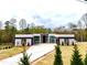 Modern home with long driveway, green lawn, and minimalist landscaping, showcasing clean lines at 0 Highway 279, Fayetteville, GA 30214