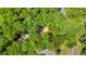 Bird's eye view showing a cozy house surrounded by dense green treetops at 115 Lake Pines Ct, Roswell, GA 30076
