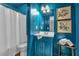 Stylish blue bathroom with a shower, framed art and a decorative vanity mirror at 115 Lake Pines Ct, Roswell, GA 30076