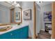 Bright bathroom with blue vanity, gold hardware and a framed mirror at 115 Lake Pines Ct, Roswell, GA 30076