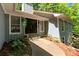 Close-up of the home's entrance, featuring a stately black door, stone steps, and garden at 115 Lake Pines Ct, Roswell, GA 30076