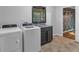 Laundry room features a washer, dryer, sink, and black cabinetry at 115 Lake Pines Ct, Roswell, GA 30076