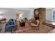 Comfortable living room with a stone fireplace, neutral walls and carpet, and plush seating at 115 Lake Pines Ct, Roswell, GA 30076
