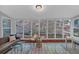 Bright sunroom featuring tiled flooring and large windows offering wooded views at 115 Lake Pines Ct, Roswell, GA 30076