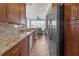 Galley kitchen featuring granite countertops, stainless steel appliances, and wood cabinets with backyard views at 200 Ne Renaissance Ne Pkwy # 304, Atlanta, GA 30308