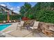 Poolside seating area featuring a stone wall and lush greenery at 200 Ne Renaissance Ne Pkwy # 304, Atlanta, GA 30308
