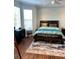 Cozy bedroom featuring a bed with a dark wooden frame, ceiling fan, and a bright window at 200 Renaissance Ne Pkwy # 304, Atlanta, GA 30308