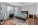 Main bedroom features wood floors, large windows, ceiling fan, dresser and a Queen sized bed at 200 Renaissance Ne Pkwy # 304, Atlanta, GA 30308