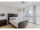 Bright bedroom featuring a dark wood bed frame, balcony access and floor to ceiling window views at 3338 Peachtree Ne Rd # 3406, Atlanta, GA 30326