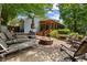 Outdoor patio with a fire pit, lounge chairs, a wooden picnic table, and a screened porch at 3912 Edenton Ne Ct, Brookhaven, GA 30319