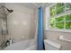 Simple bathroom with a bathtub and shower combination, a blue shower curtain, and a window at 3912 Edenton Ne Ct, Brookhaven, GA 30319