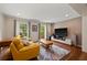 Bright living room featuring hardwood floors, recessed lighting, two large windows, a yellow couch and modern entertainment center at 3912 Edenton Ne Ct, Brookhaven, GA 30319